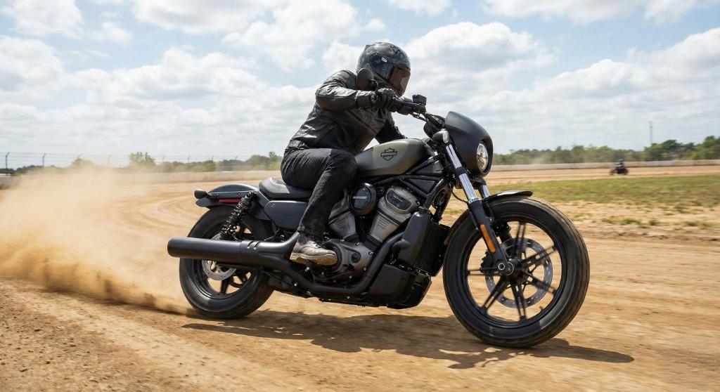 A rider testing the 2025 Harley-Davidson Nightster motorcycle on a dirt flat track course, kicking up dust around a corner